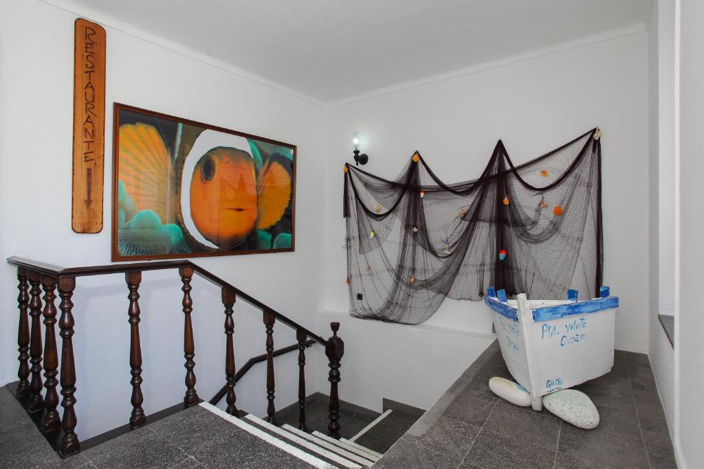 a hallway with a staircase with a painting on the wall at Aparthotel Barracuda in Ponta Delgada