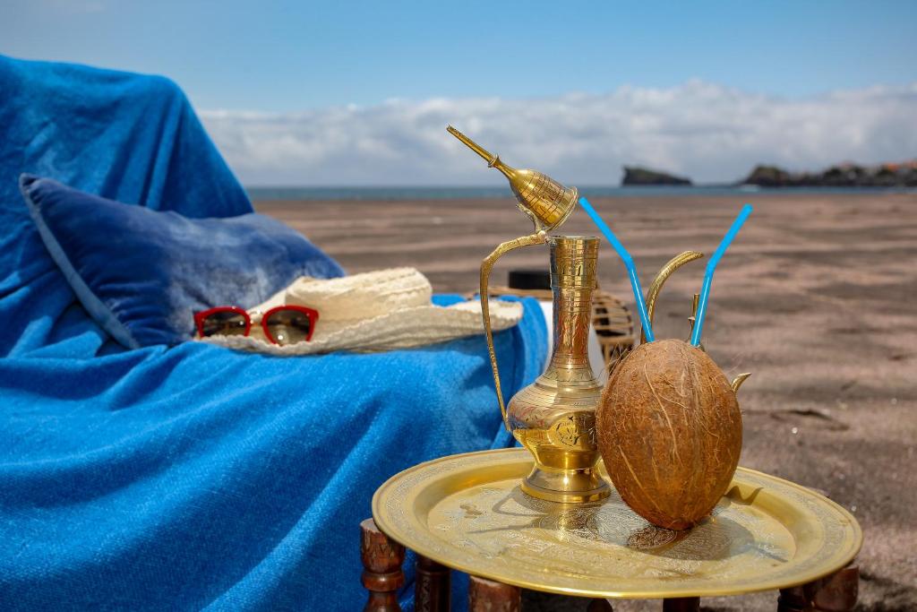 a close up of a bottle and a coconut on a table at Aparthotel Barracuda in Ponta Delgada