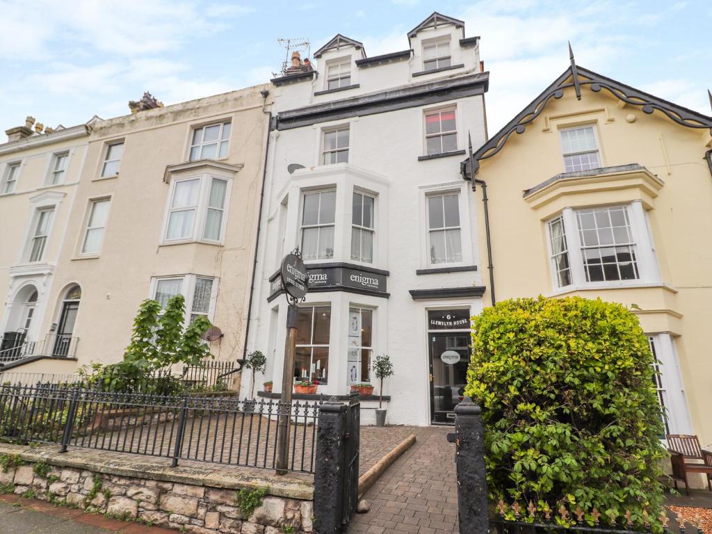 een groot wit huis met een hek ervoor bij Llewelyn House in Llandudno