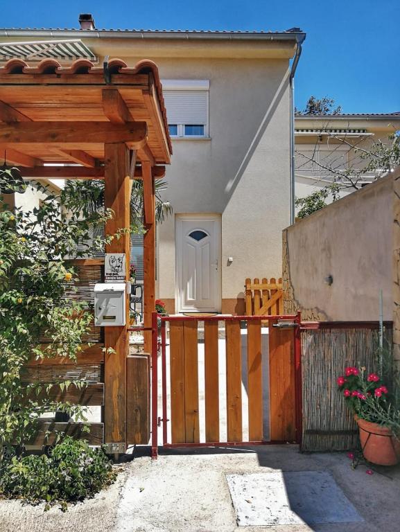 a wooden gate to a house with a fence at Jasmina in Senj
