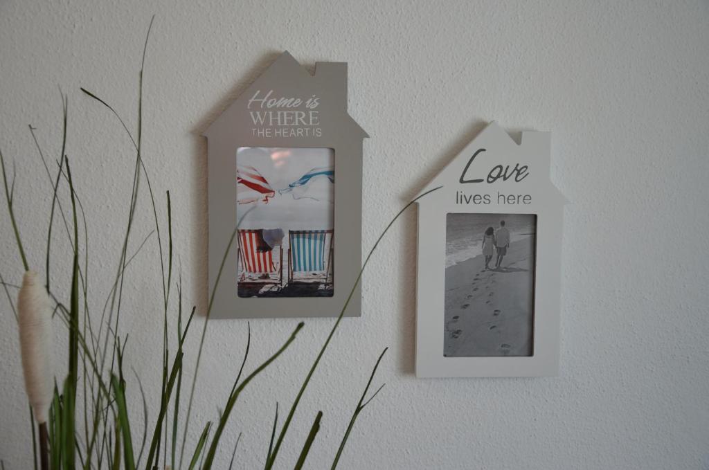 two pictures on a wall with a picture of a beach at ABLA Guest House in Carcavelos