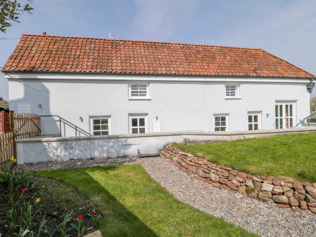 uma casa branca com um telhado vermelho em Avonside Cottage em Bristol