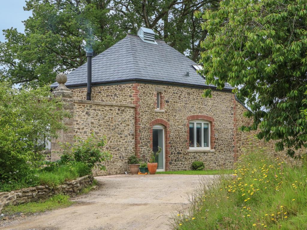 a brick house with a gray roof and a driveway at The Old Laundry in North Tawton