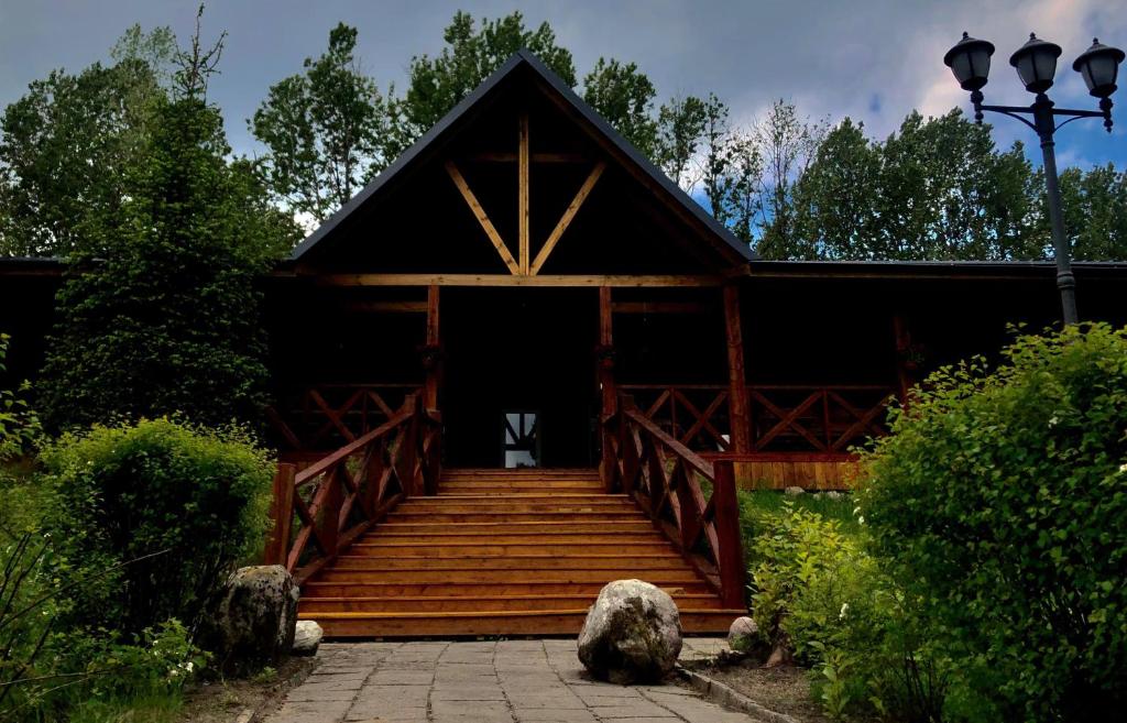 una casa con una escalera de madera que conduce a un porche en KANAAN Ośrodek Wczasowy, en Miastko