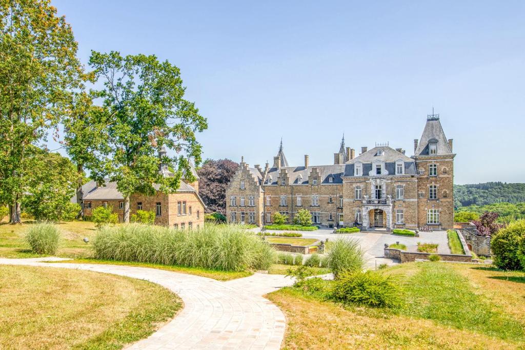 een landgoed in de heuvels met een pad dat er naar toe leidt bij Domaine de Ronchinne - Château et Ecuries in Maillen