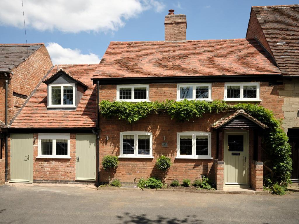 a brick house with ivy growing on it at 67 Bridge End in Warwick