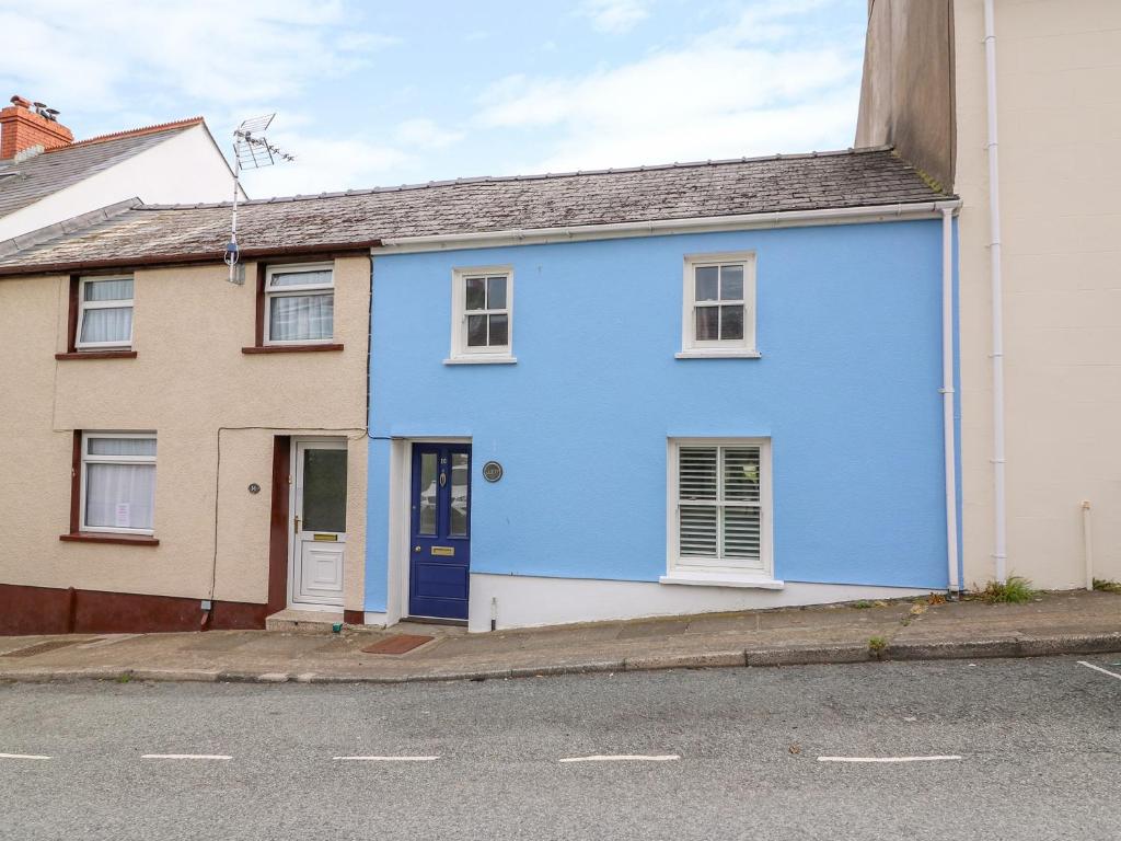 uma casa azul ao lado de uma rua em Llety em Fishguard