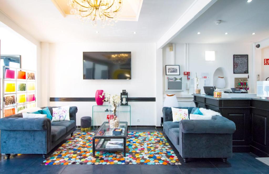 a living room with two couches and a coffee table at Hôtel Le Mistral in Marseille