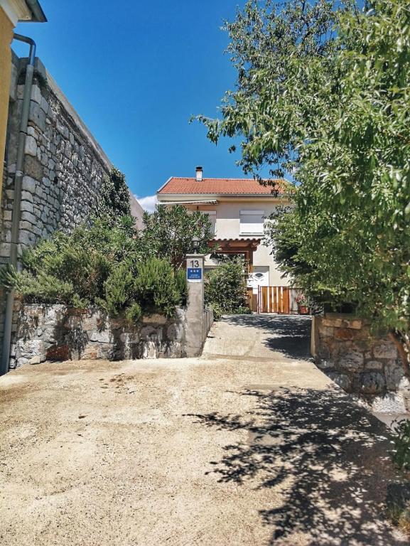 a house with a stone wall and a driveway at Jasmina in Senj