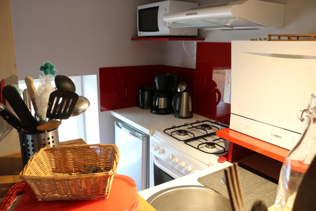 a kitchen with a white stove top oven next to a counter at Gite Le Meix Chapeau in Levernois
