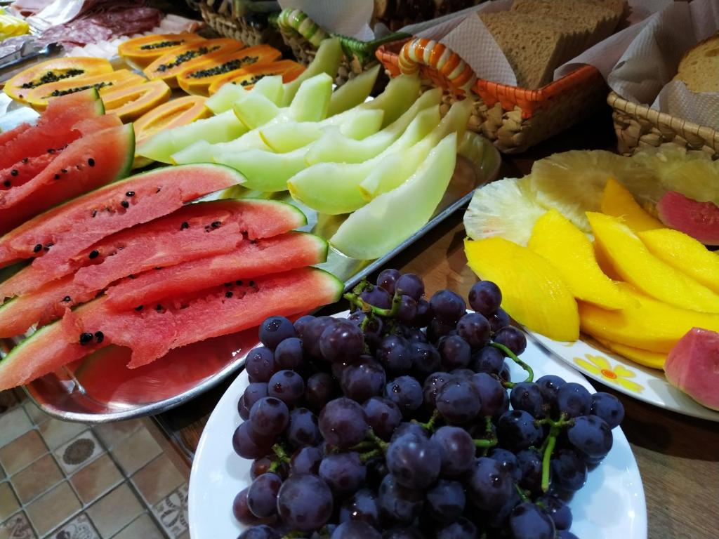 a table topped with plates of fruit and vegetables at Pousada Recanto das Águas in Lumiar