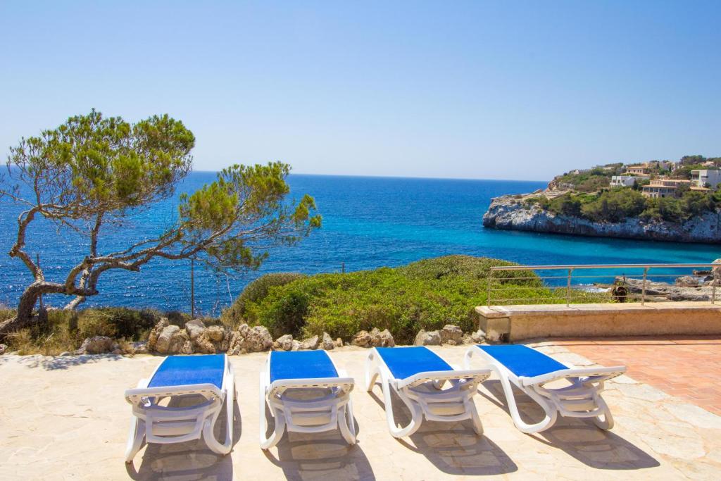 a group of lounge chairs sitting on a beach at Beautiful private villa on the sea in Santanyi
