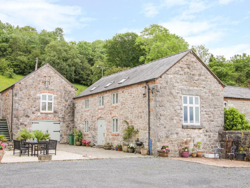 an old stone house with solar panels on it at Graig Gwyn Cottage in Oswestry