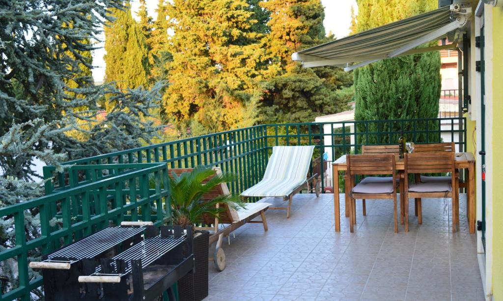 eine Terrasse mit einem Tisch, Stühlen und einem Sonnenschirm in der Unterkunft Apartments Vuković in Stari Grad
