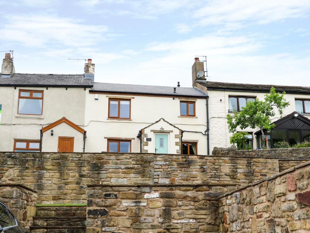 a house behind a stone wall at Windmill Cottage in Blackburn