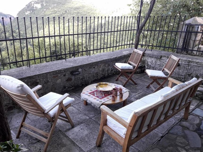three chairs and a coffee table on a patio at Wanderer's Lodge in Sparti