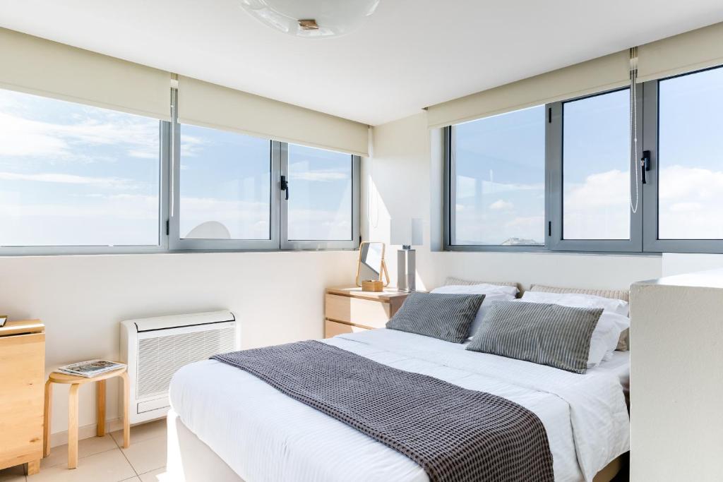 a white bedroom with windows and a bed at GB Athens View Luxury Suite in Athens