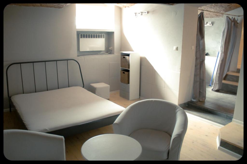 a room with a bed and two chairs and a table at Apartamenty 8 in Poznań