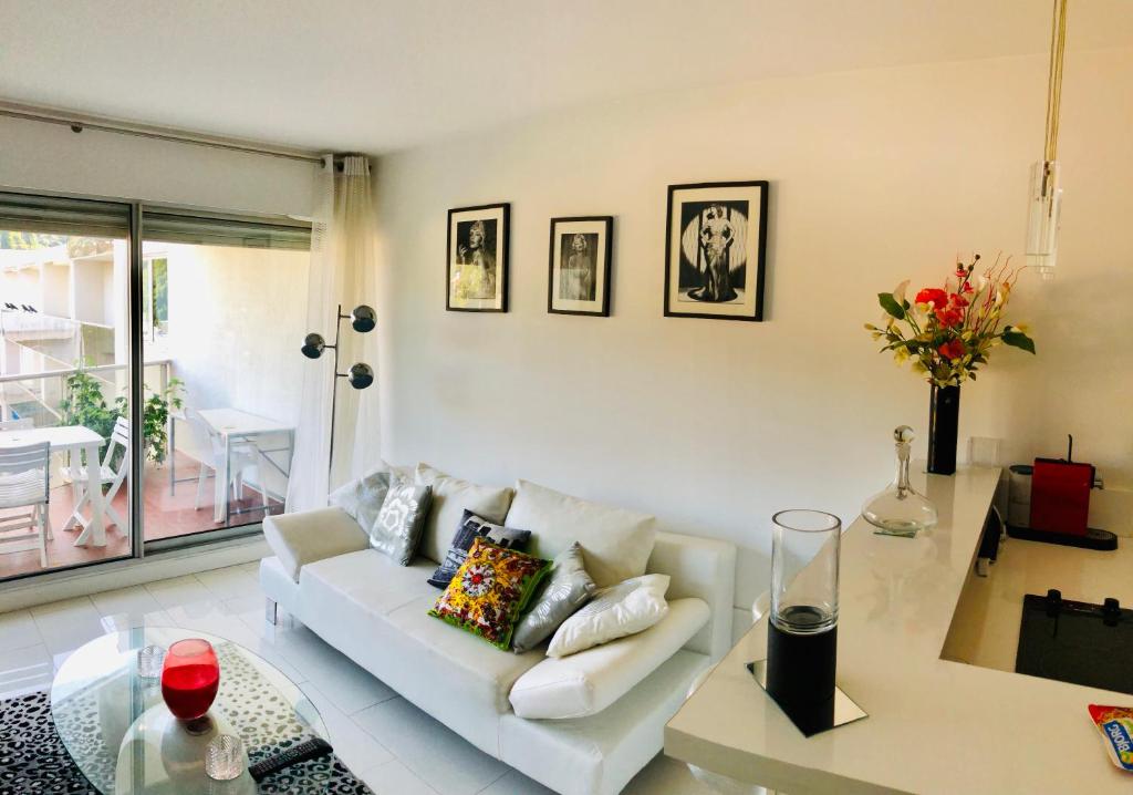 un salon avec un canapé blanc et une table en verre dans l'établissement PERE LACHAISE - MONTMARTRE Paris centre, à Paris