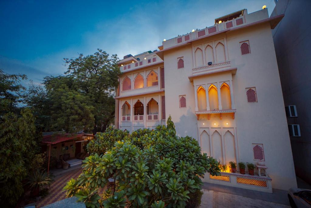 un gran edificio blanco con árboles delante de él en Hotel H R Palace, en Jaipur