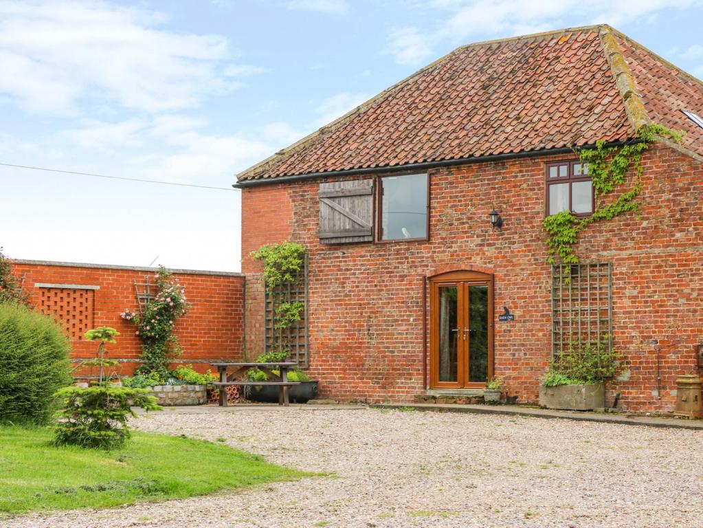 una casa de ladrillo rojo con un patio frente a ella en Barn Owl, en Louth