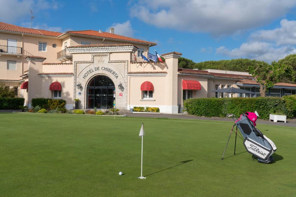 a golf ball on a putting green in front of a building at Hôtel et Résidence de Chiberta et du Golf in Anglet