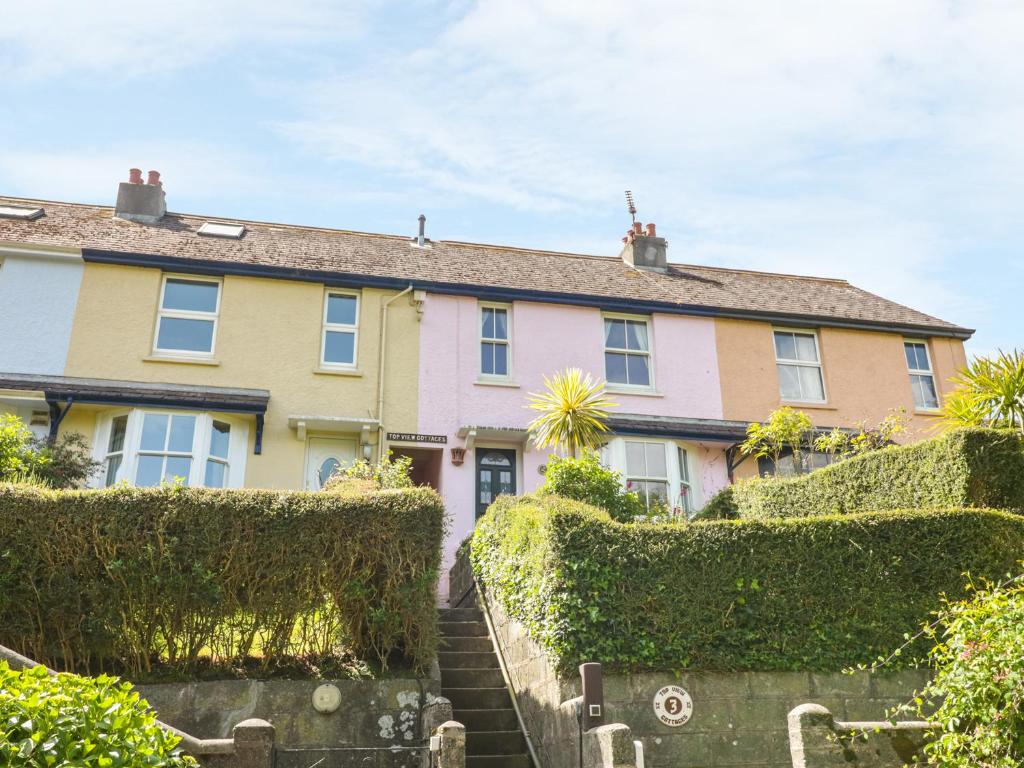 een rij huizen met struiken voor hen bij 3 Top View Cottages in Salcombe