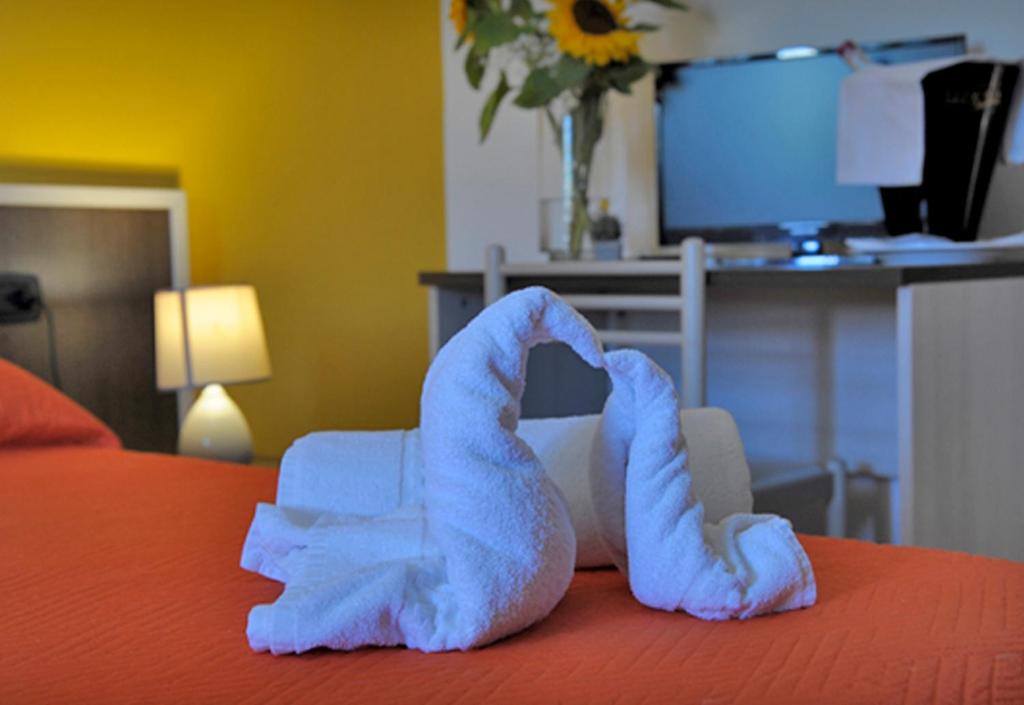 a pair of towel animals on top of a bed at Hotel Marina in Badesi