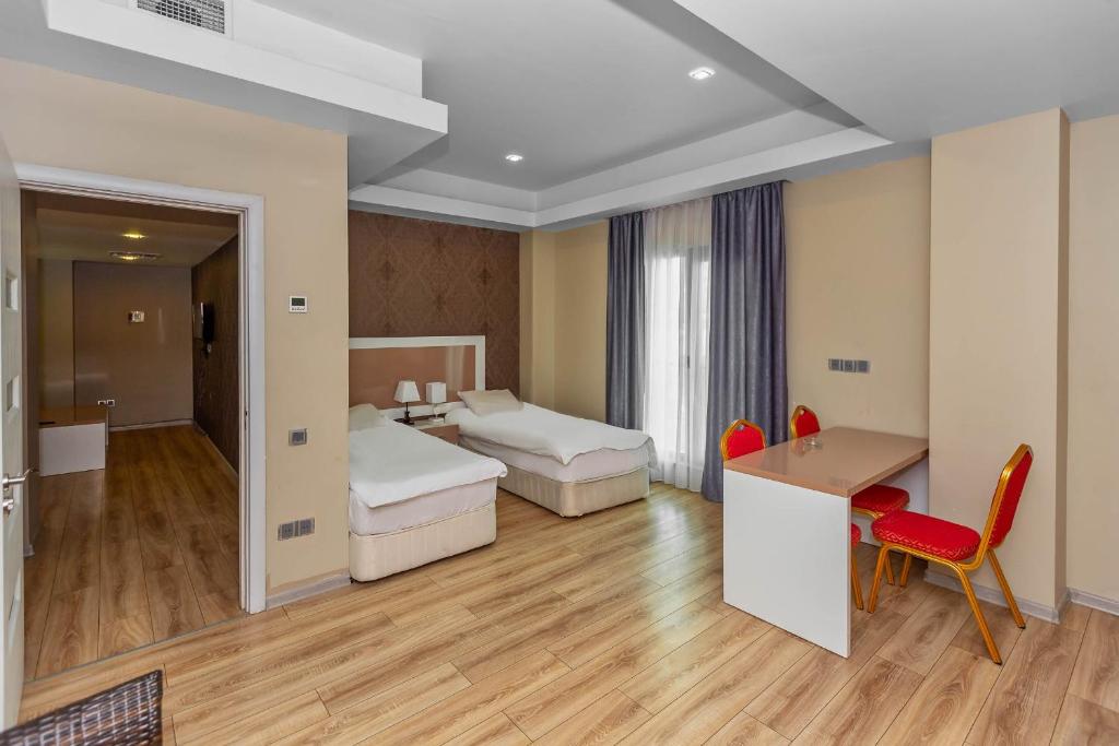 a hotel room with two beds and a desk at Diplomat Suites in Baku