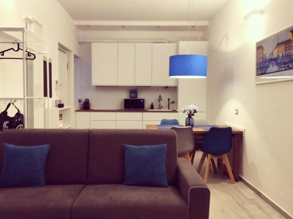 un salon avec un canapé et une table et une cuisine dans l'établissement LOVELY MILANO - Brand new stylish apartment in Navigli Area, à Milan
