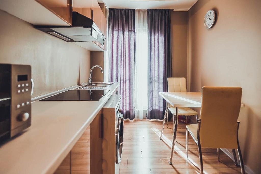 a kitchen with a sink and a table with chairs at Diplomat Suites in Baku