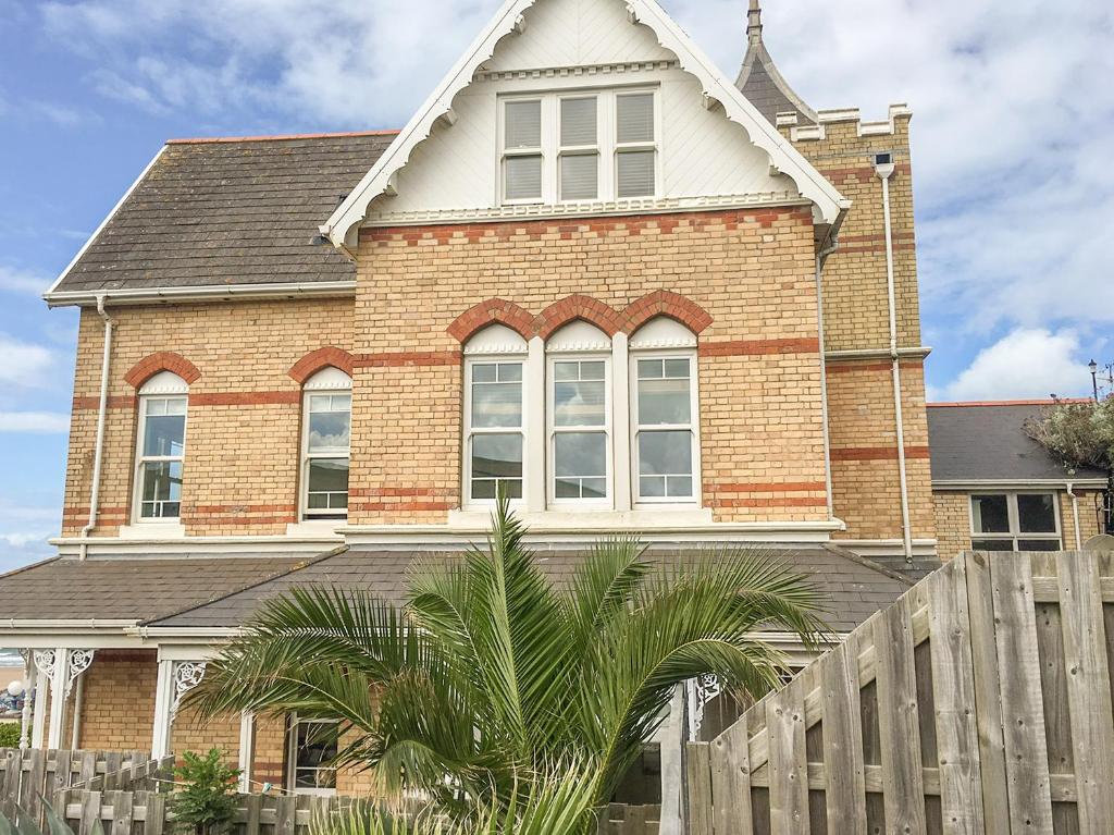 a brick house with a wooden fence in front of it at Seashore in Woolacombe