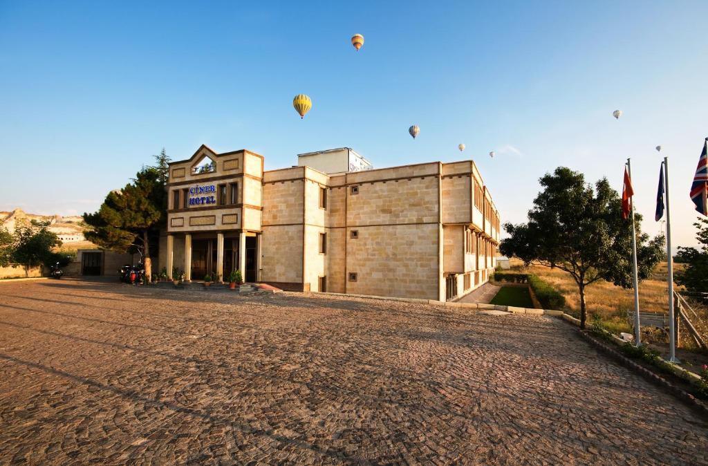 ein großes Gebäude mit Drachen, die in den Himmel fliegen in der Unterkunft Ciner Hotel in Goreme