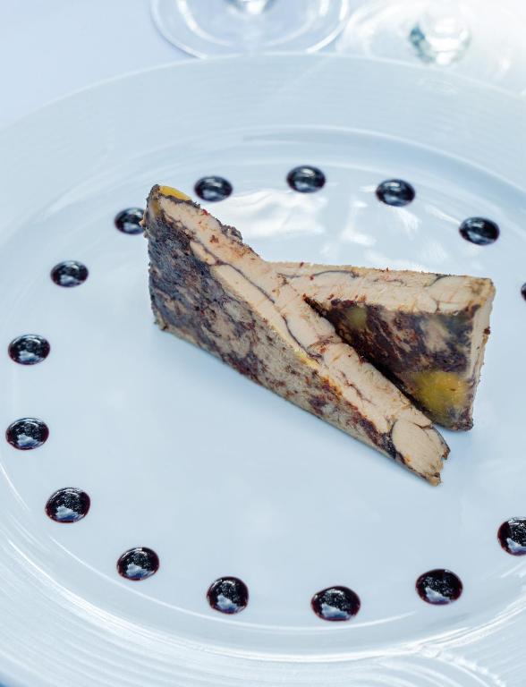 a piece of cake on a white plate with blueberries at Hôtel et Résidence de Chiberta et du Golf in Anglet