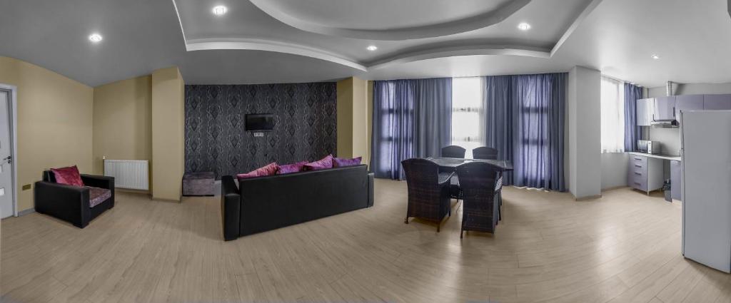 a living room with a table and chairs and a kitchen at Diplomat Suites in Baku