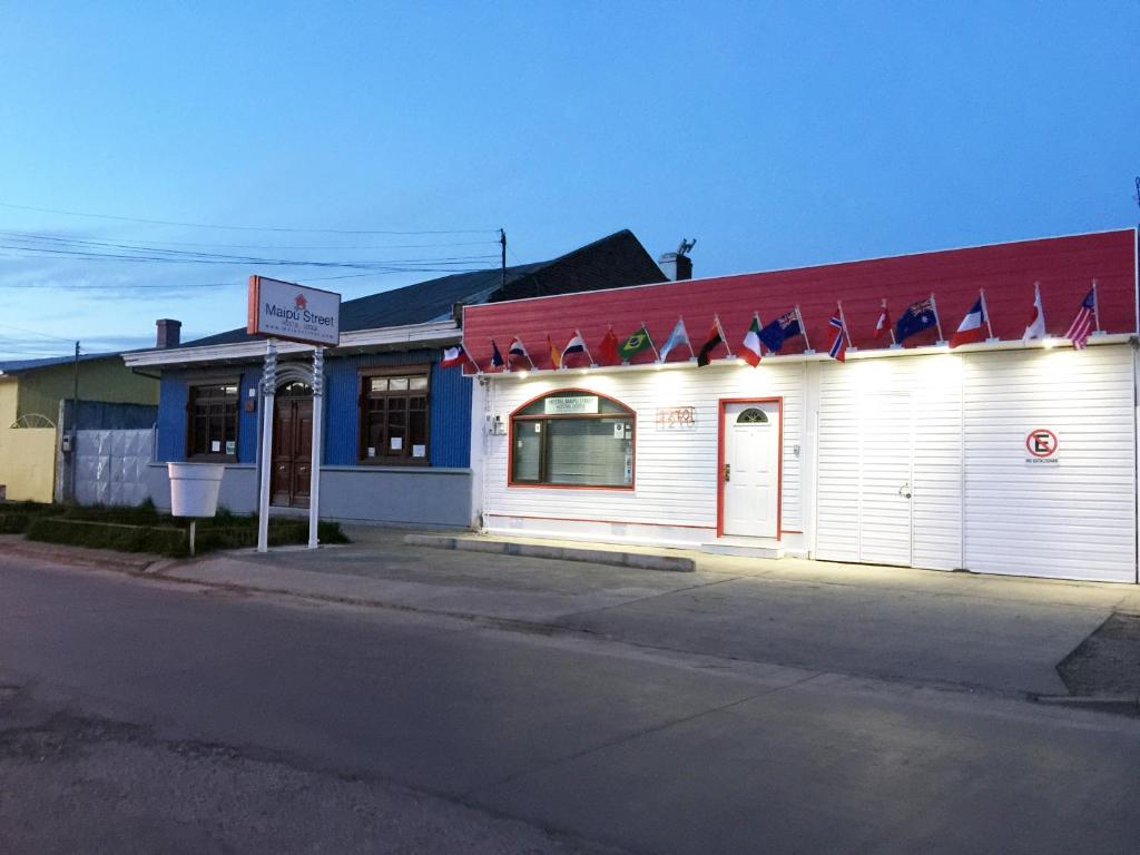 un edificio blanco con techo rojo en una calle en Hostal Maipu Street, en Punta Arenas