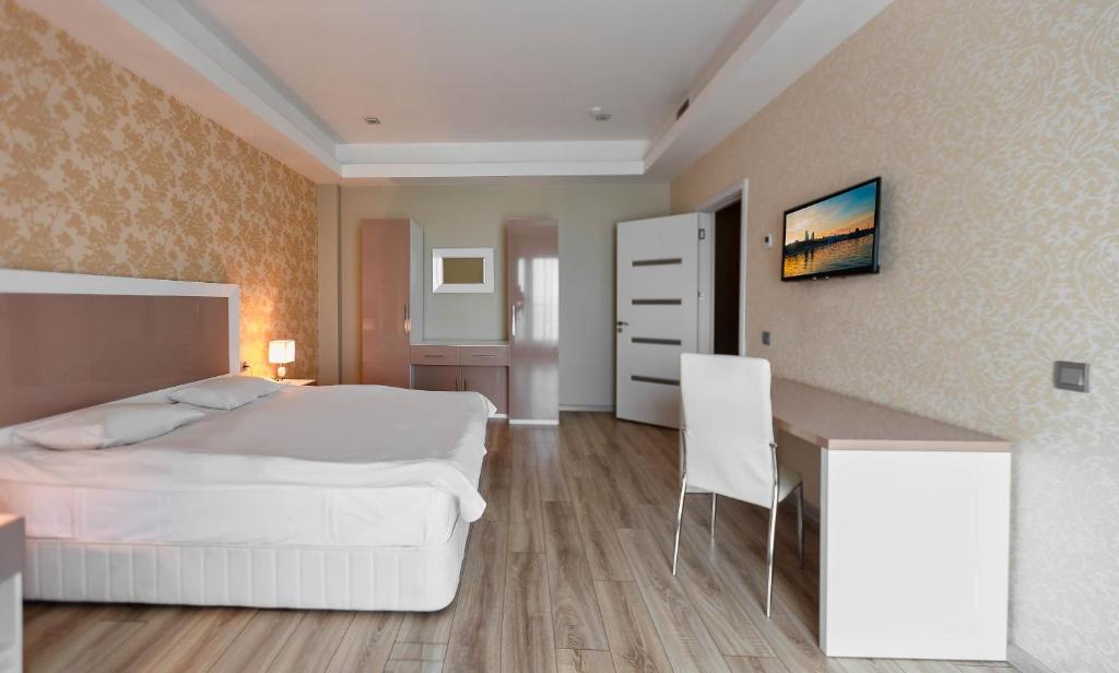 a bedroom with a white bed and a desk at Diplomat Suites in Baku