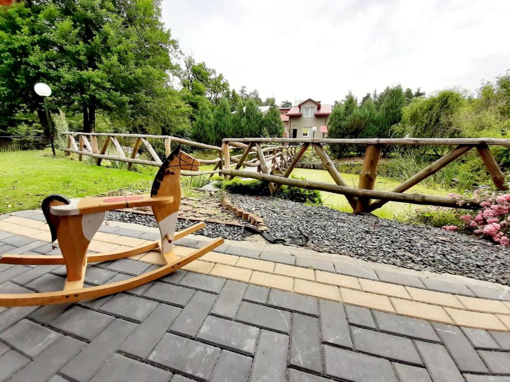 a wooden rocking horse sitting on a patio at Gospodarstwo Agroturystyczne Pod Lasem Maria Płazio in Narol