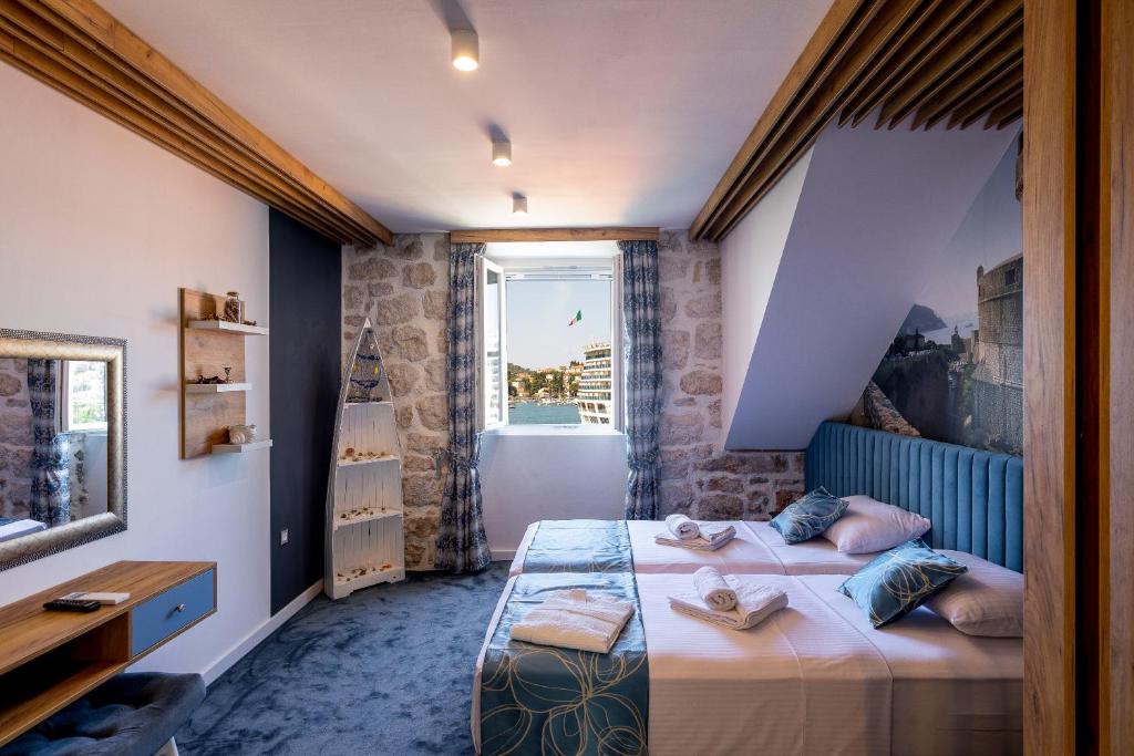 1 dormitorio con 2 camas y ventana en Apartments and Rooms Villa Naida, en Dubrovnik