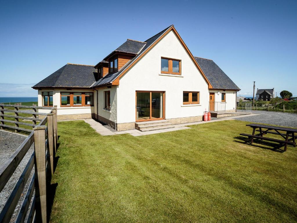 a house with a large yard with a picnic table at Corsewall Castle Farm Lodges in Stranraer