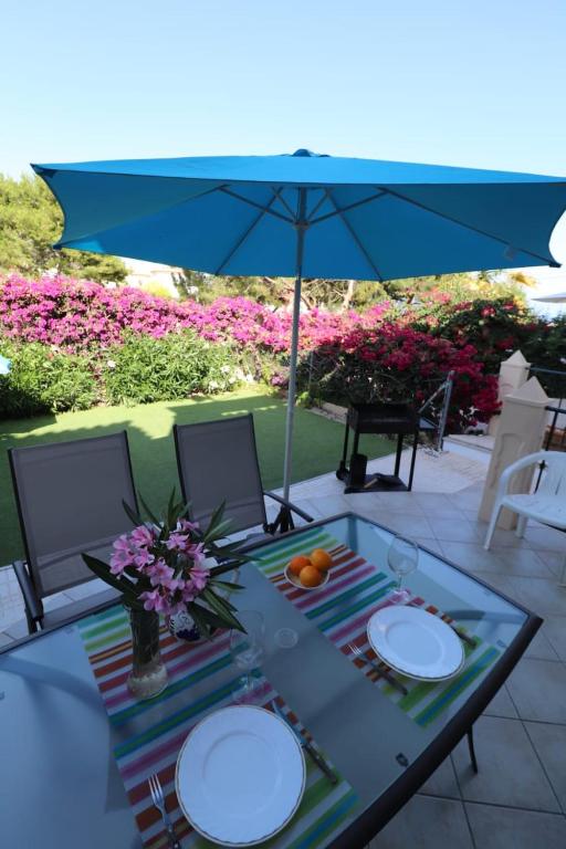 a table with two plates and an umbrella at Calanuza in El Campello