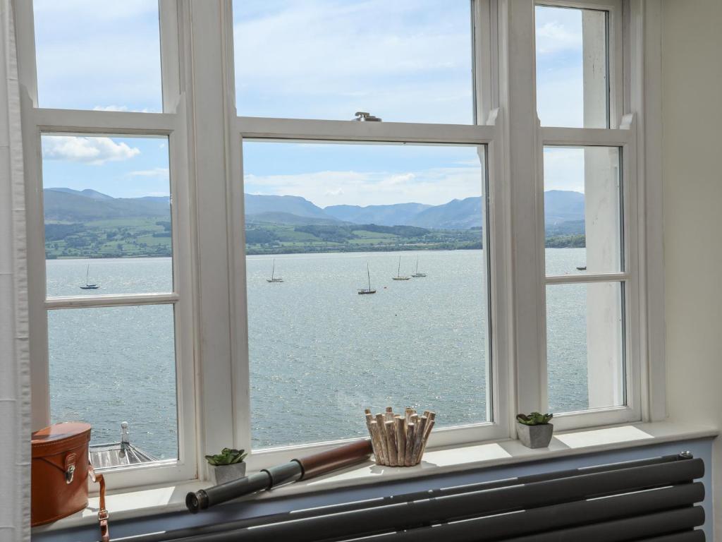 una finestra con vista sull'acqua e sulle barche di Gadlys House - Beau View a Beaumaris
