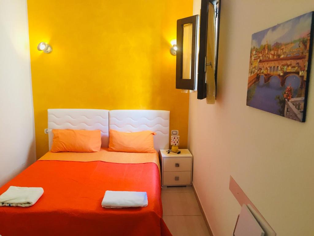 um quarto com uma cama com paredes laranja e amarela em DiVino Marsala centro em Marsala