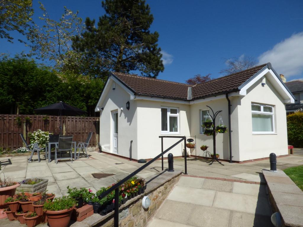 a small white house with a patio at The Bungalow in Burnley