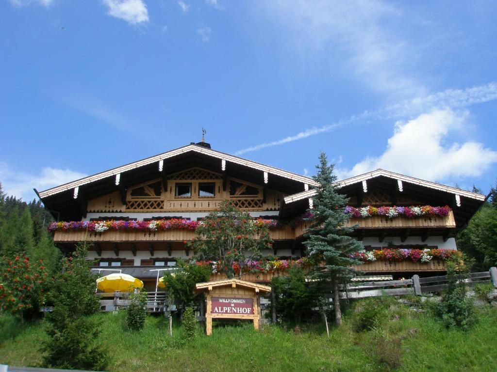 ein Gebäude mit Blumen auf der Seite in der Unterkunft Alpenhof Schwaiger - Hotel Garni in Mühlbach am Hochkönig