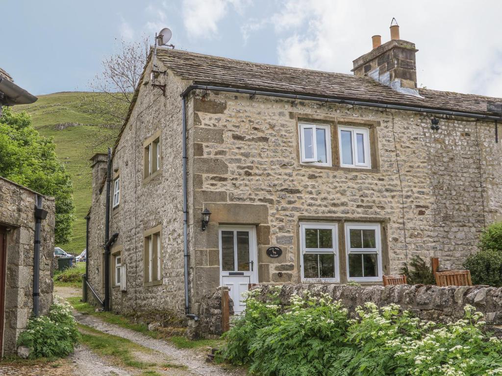 uma antiga casa de pedra com uma parede de pedra em Dale View em Skipton