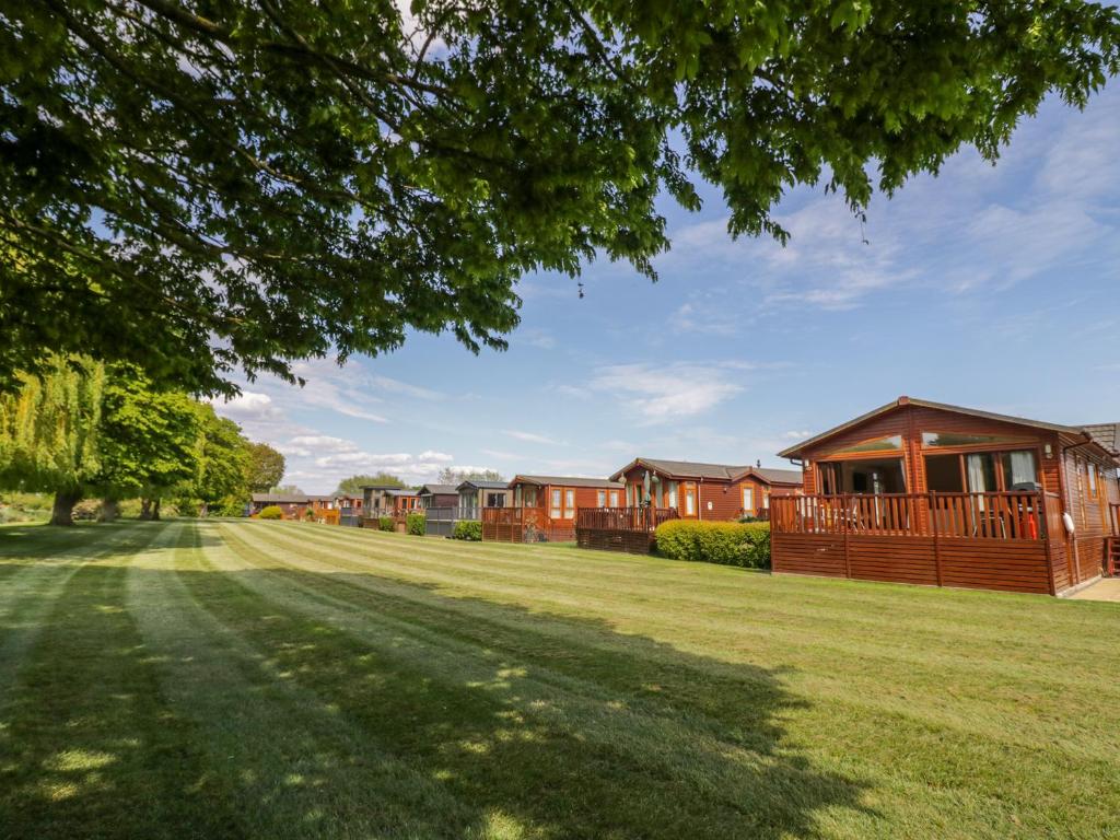 a row of houses in a park with a yard at Booster's Lodge in Stratford-upon-Avon