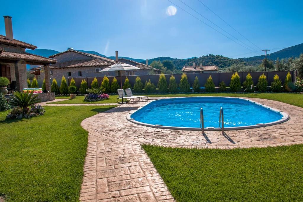 a swimming pool in the middle of a yard at Villa Argie in Nea Epidavros