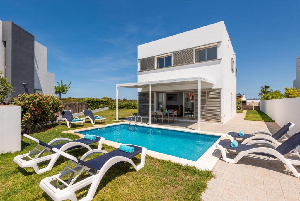 una villa con piscina e sedie a sdraio di Villa 26 a Cala'n Bosch