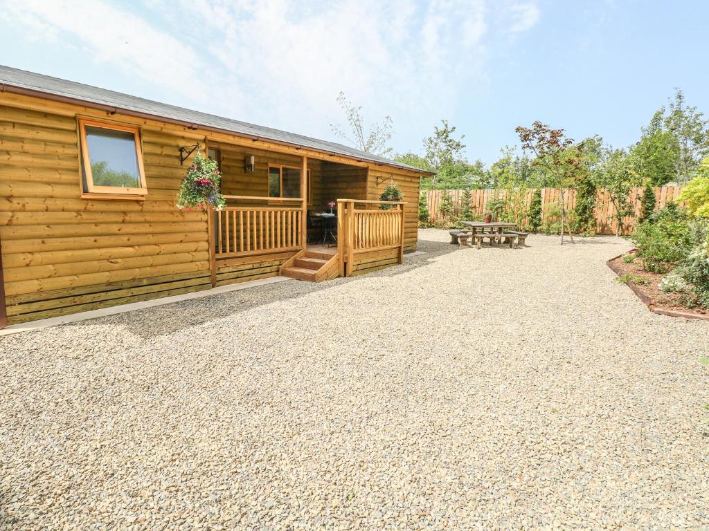 Cabaña de madera con patio y mesa de picnic en Willow Lodge, en Tenby